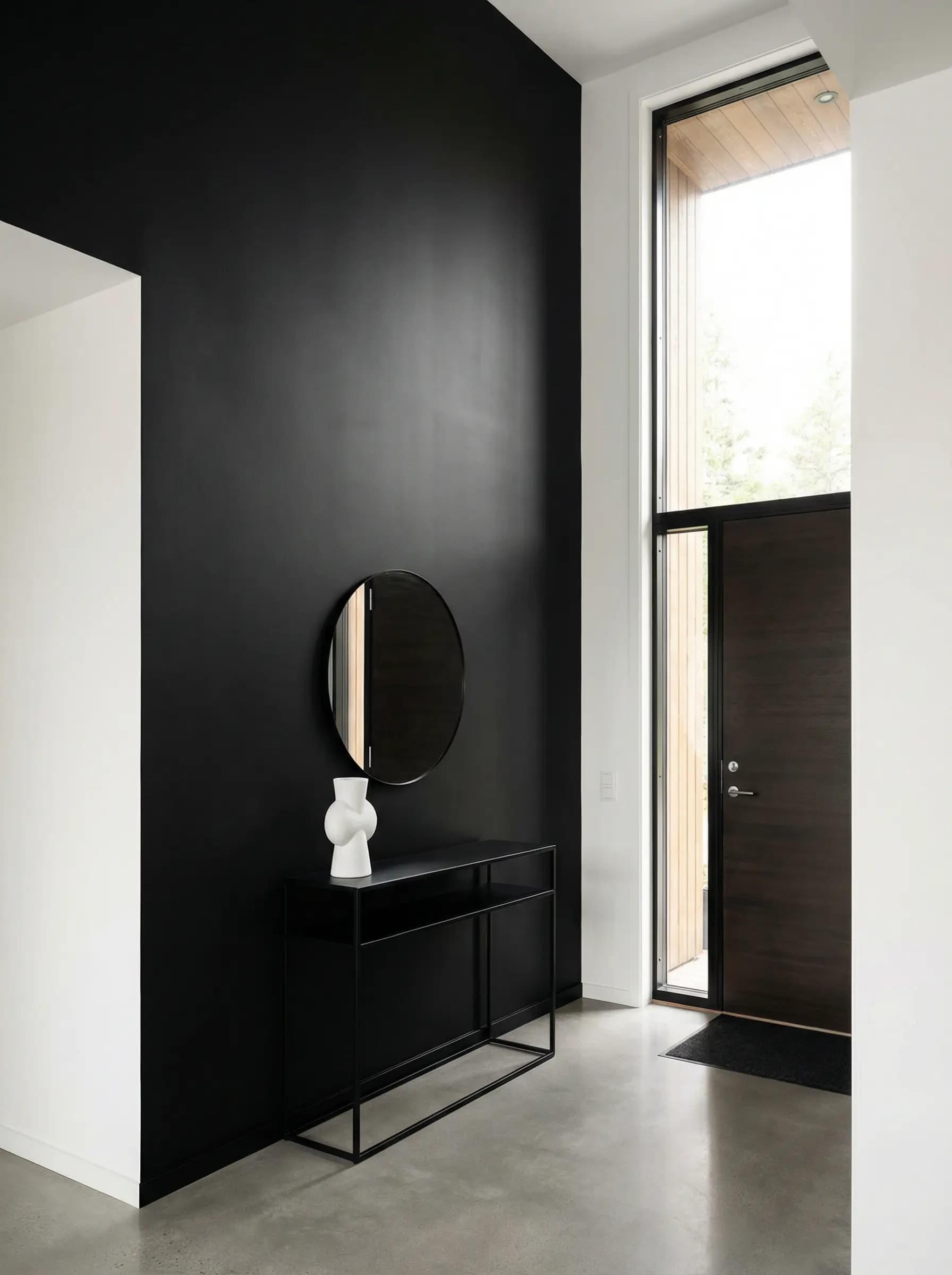 Modern entryway featuring a dramatic black accent wall with a welcoming atmosphere